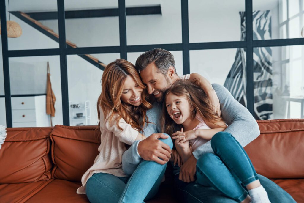 Family happily hugging each other on a couch